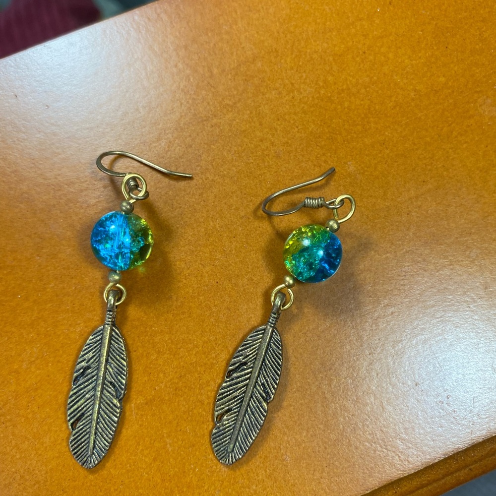 A set of (metal?) feather earrings. Never worn.